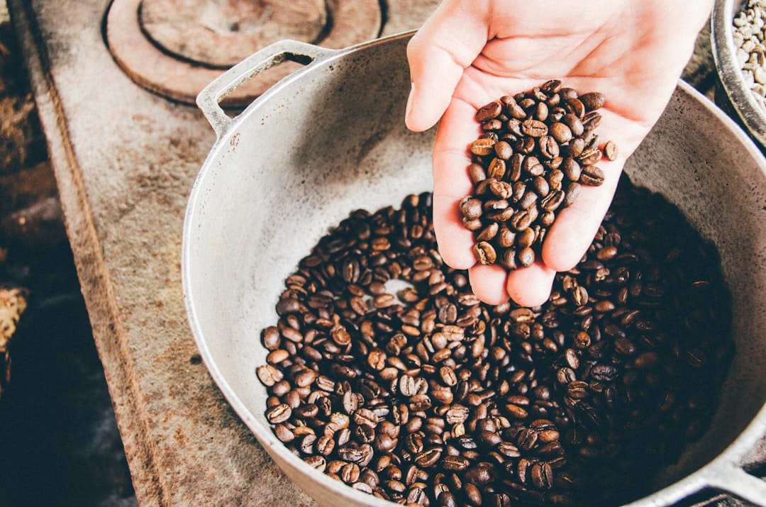 Decaf coffee beans in a burlap sack with a scoop, roasted Arabica beans scattered around