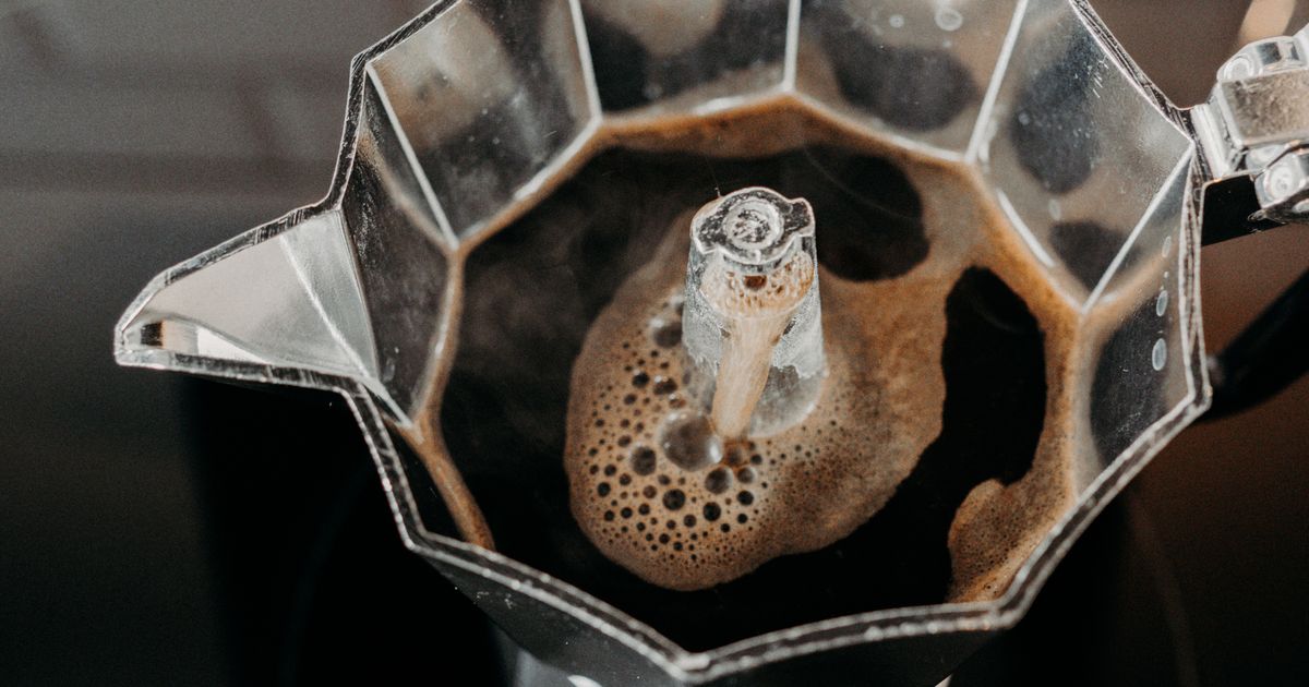 Moka pot brewing rich stovetop coffee with steam rising