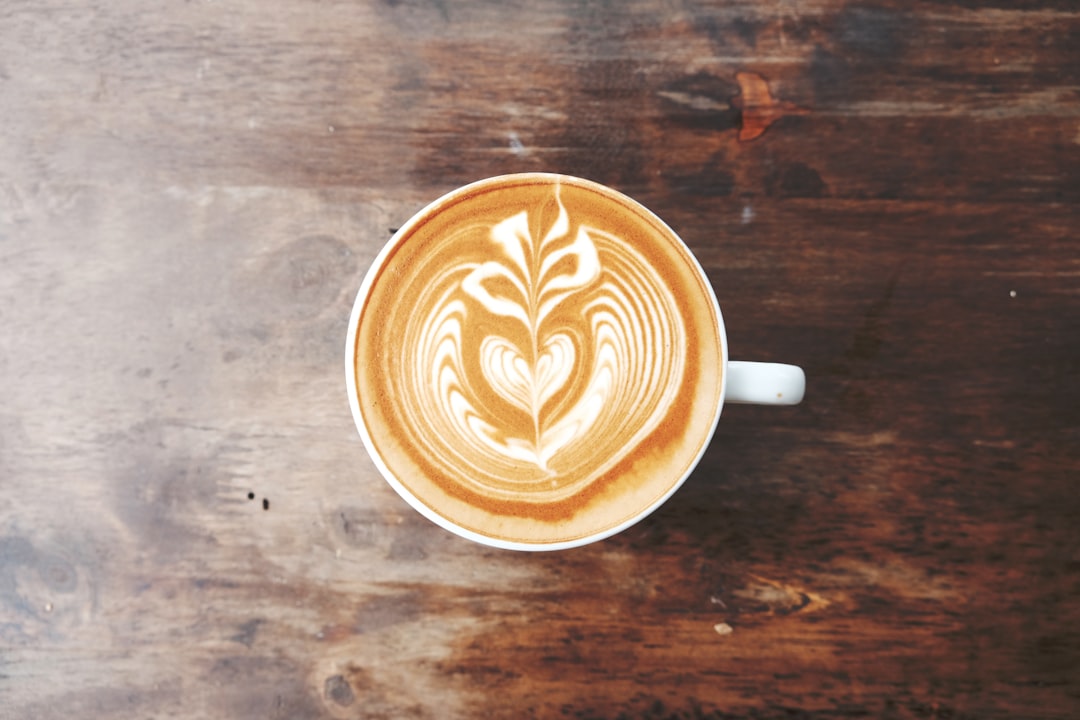 Three coffee drinks in white cups showing different milk foam textures