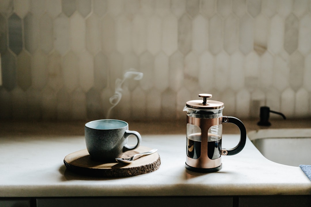 French press cafetiere with brewed coffee and plunger on a kitchen counter